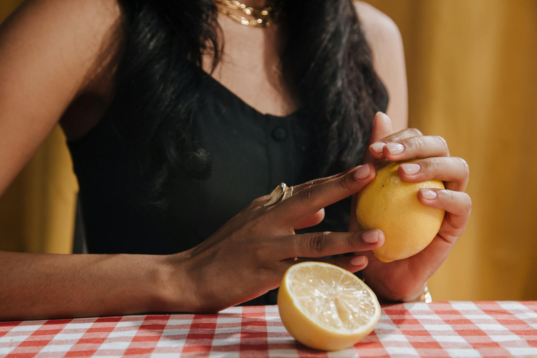 Close-up of hands holding fresh lemons, representing the brightness and sensation of using a lemon vibrator with adapted technique