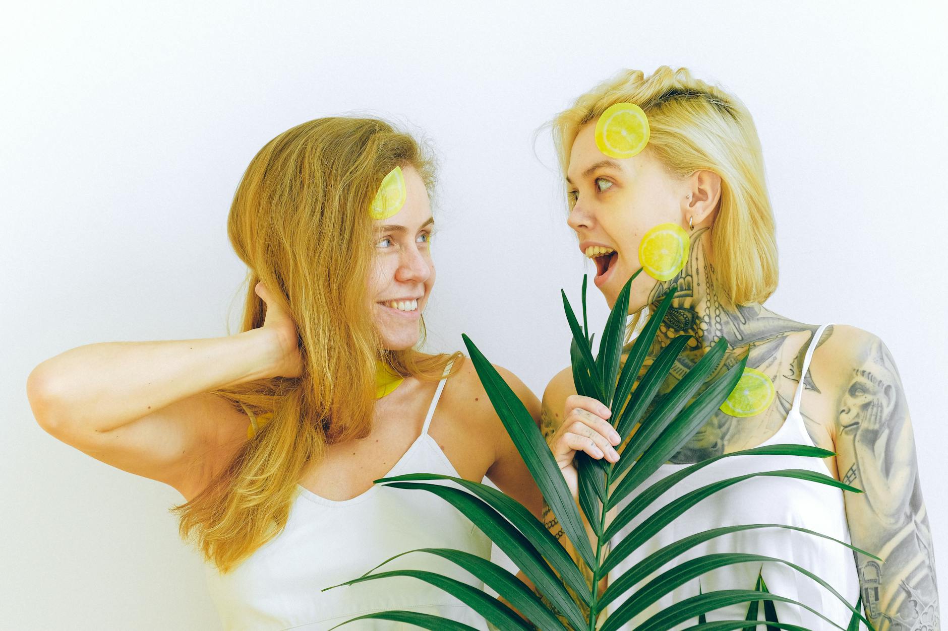 Two women smiling with lemon slices, expressing joy and comfort with each other