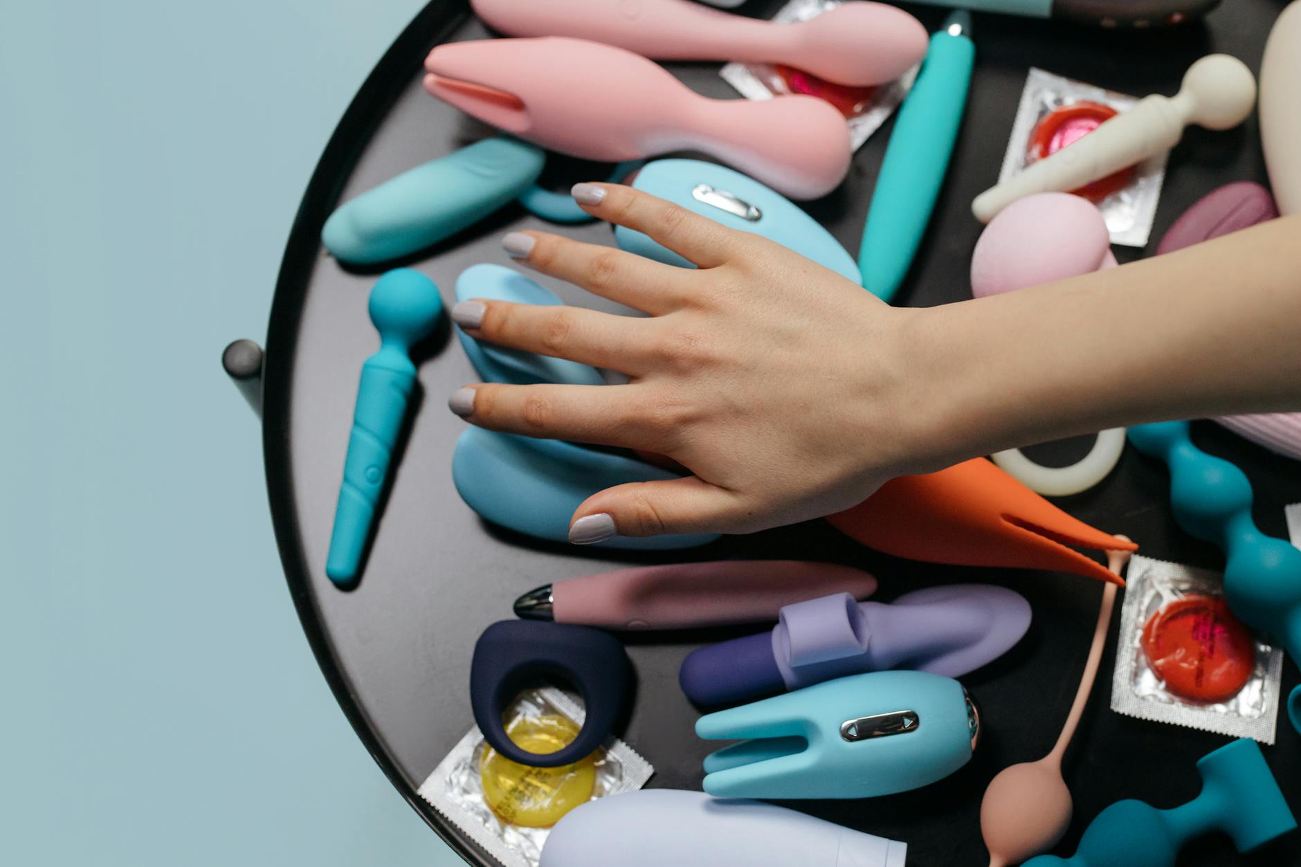A hand holding a lemon clitoral vibrator against a minimalistic purple backdrop, showcasing modern sensuality