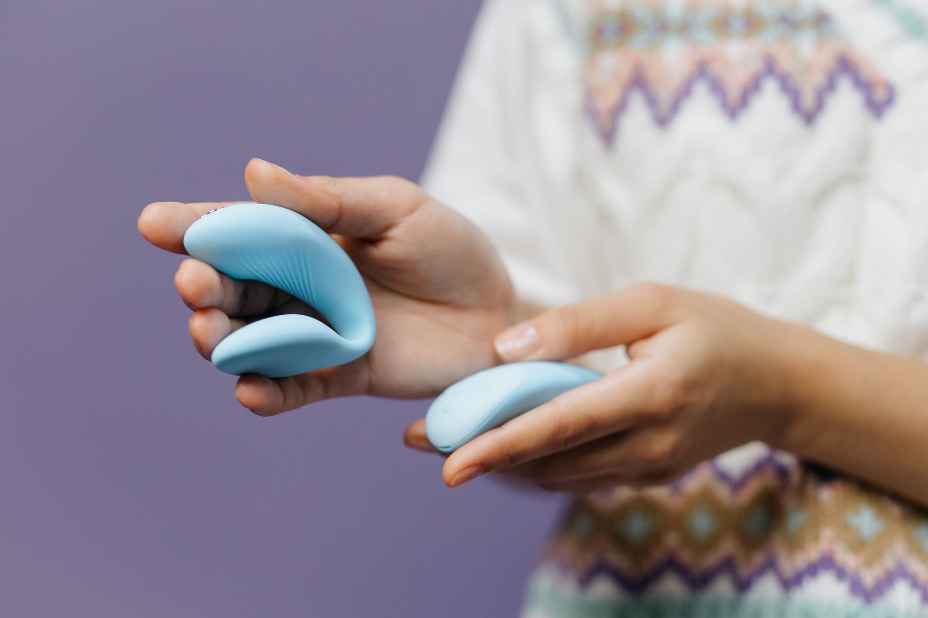 Hands holding a sleek blue vibrator, representing solo pleasure and intimate reconnection.
