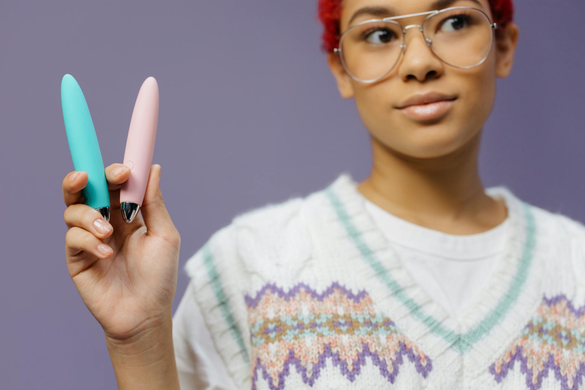 Hands gently holding colorful vibrators representing self-care and reconnection